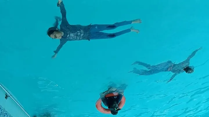Children practicing in the swimming pool.