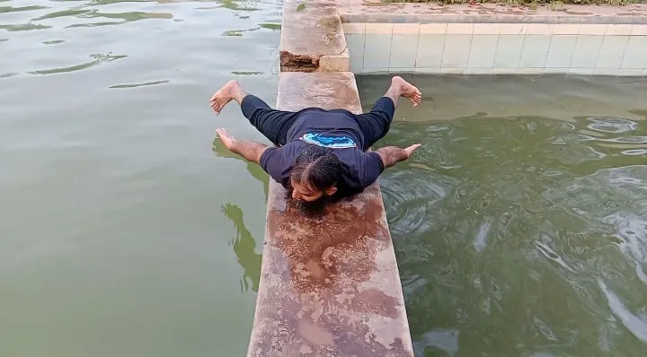 Zeeshan demonstrating breaststroke movement outside the pool.