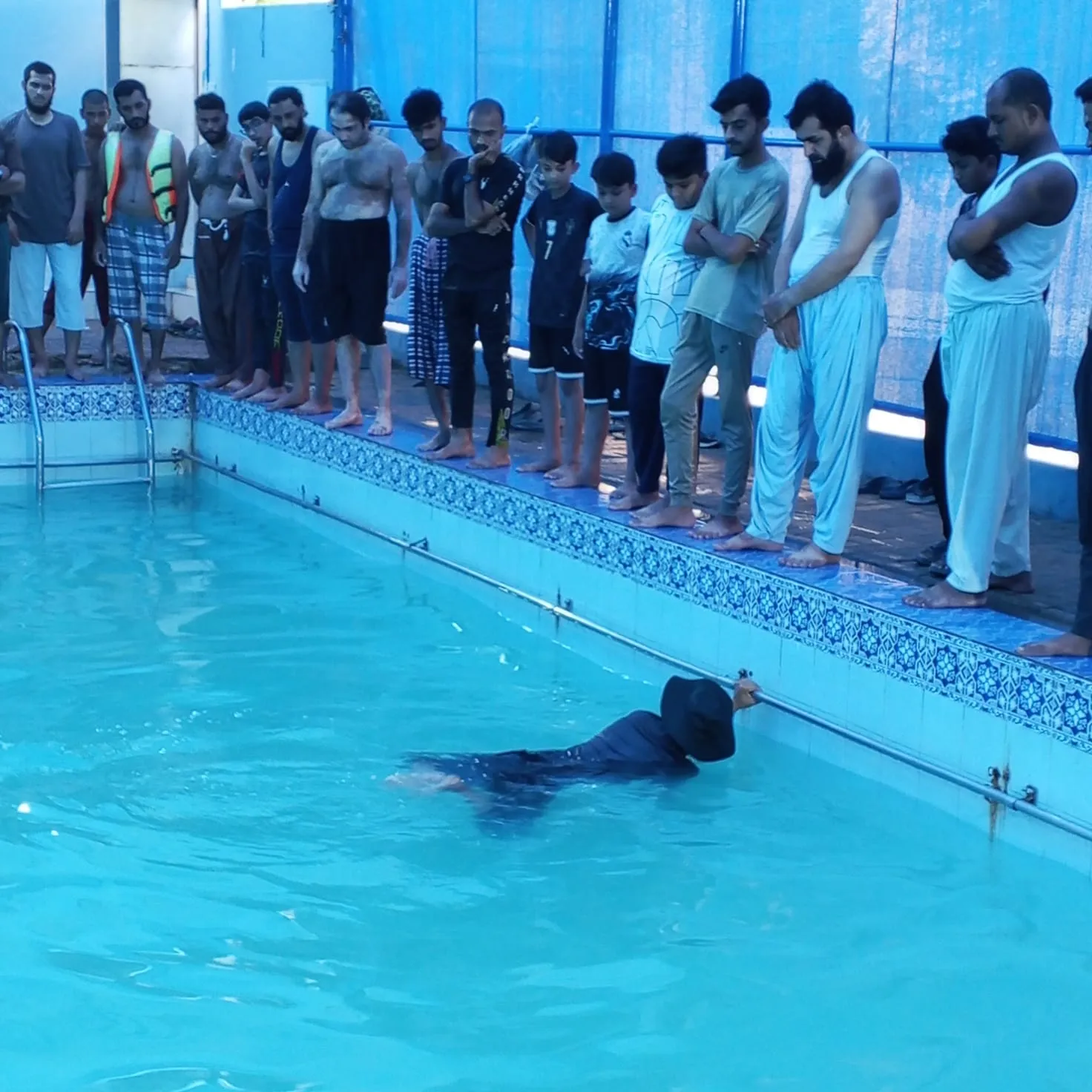 Zeeshan in the pool while students watch from outside.