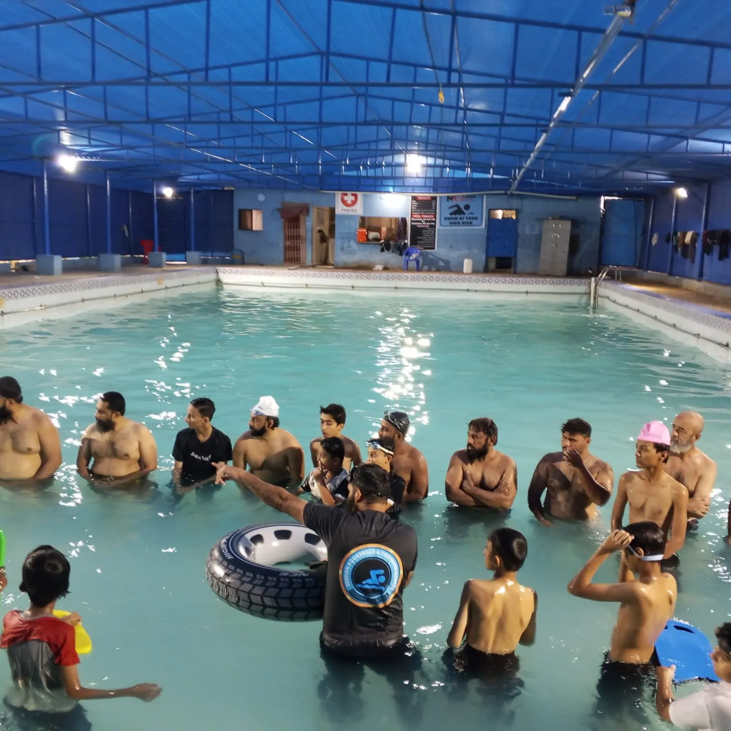 Zeeshan guiding a learner with a swimming tyre in the pool.